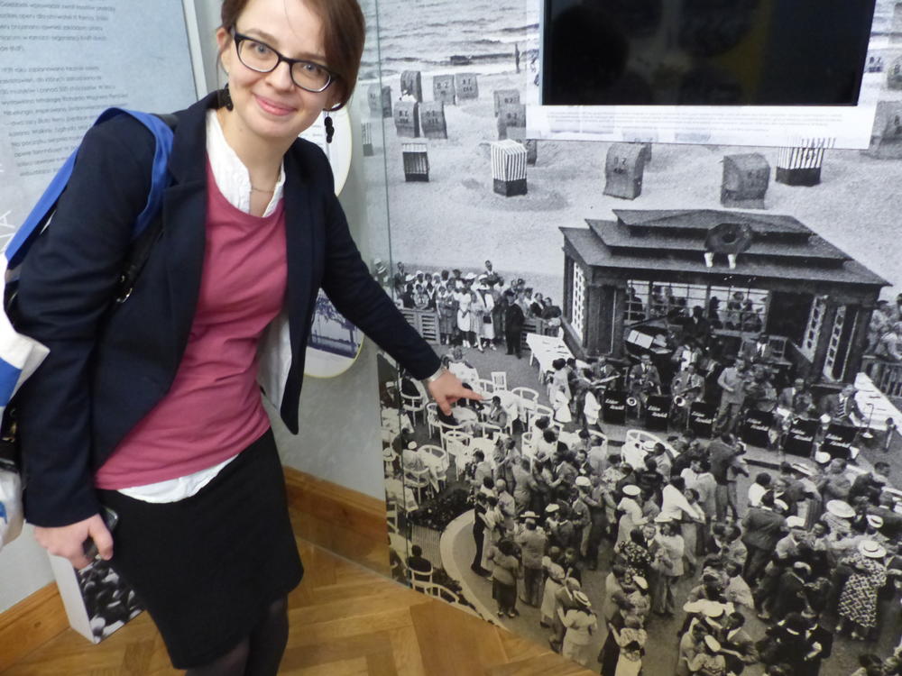 Curator Jagoda Załęska-Kaczko identifies the chair on the historic photograph